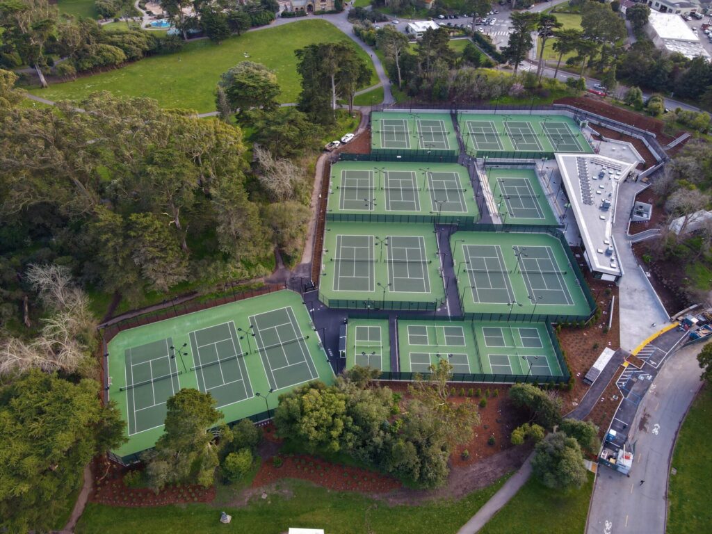 Aerial view of 16 tennis courts and 5 pickleball courts at the Lisa & Douglas Goldman Tennis Center at Golden Gate Park in San Francisco. The entire tennis center was fully renovated in 2020 and 2021. The courts were surfaced using Plexipave acrylic in Florida Green and light Green.