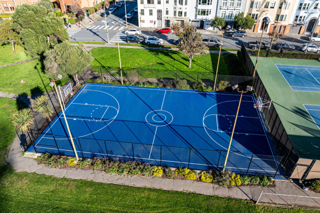 Aerial view of the basketball court at Moscone Park in San Francisco. The courts were refurbished using the slipsheet overlay system and surfaced using Plexipave acrylic resurfacer and color in medium green and dark blue